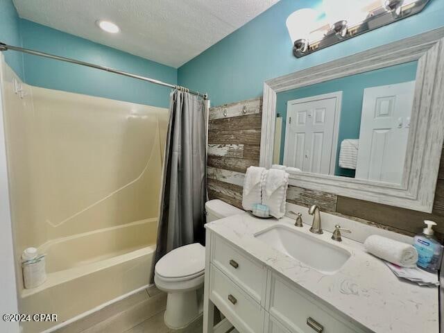 full bathroom featuring a textured ceiling, vanity, shower / tub combo, and toilet