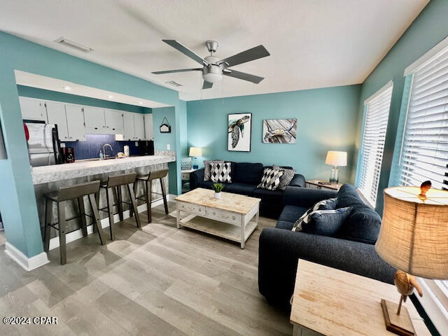 living room featuring light hardwood / wood-style floors and ceiling fan