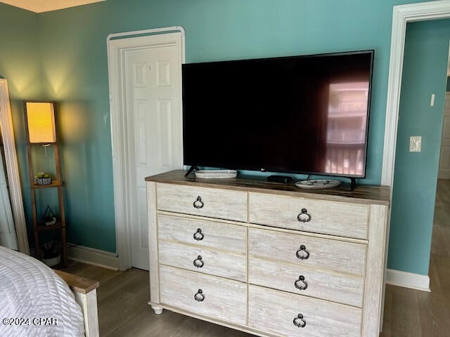 bedroom with dark hardwood / wood-style flooring