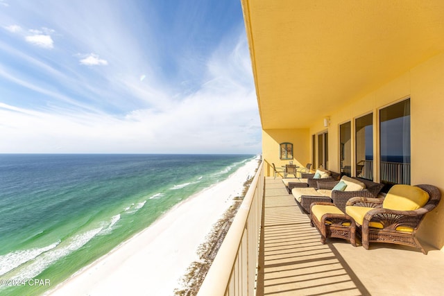 balcony with a water view, outdoor lounge area, and a view of the beach