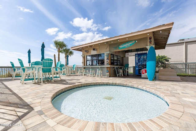 view of swimming pool with a bar and a patio area