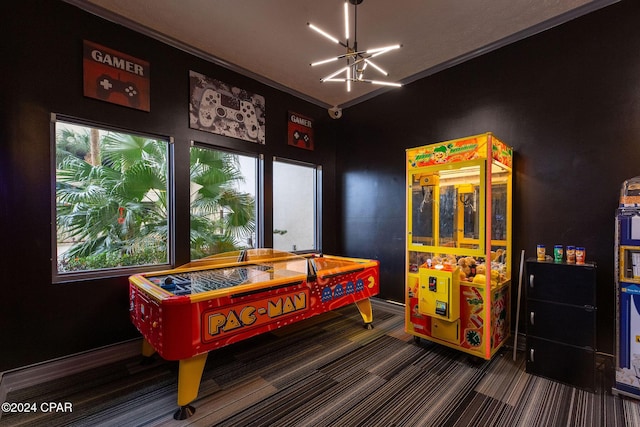 rec room featuring dark colored carpet and an inviting chandelier