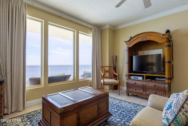 living room with ornamental molding, light tile patterned floors, ceiling fan, a water view, and a textured ceiling