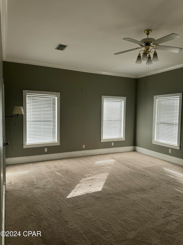 carpeted empty room with ceiling fan and ornamental molding