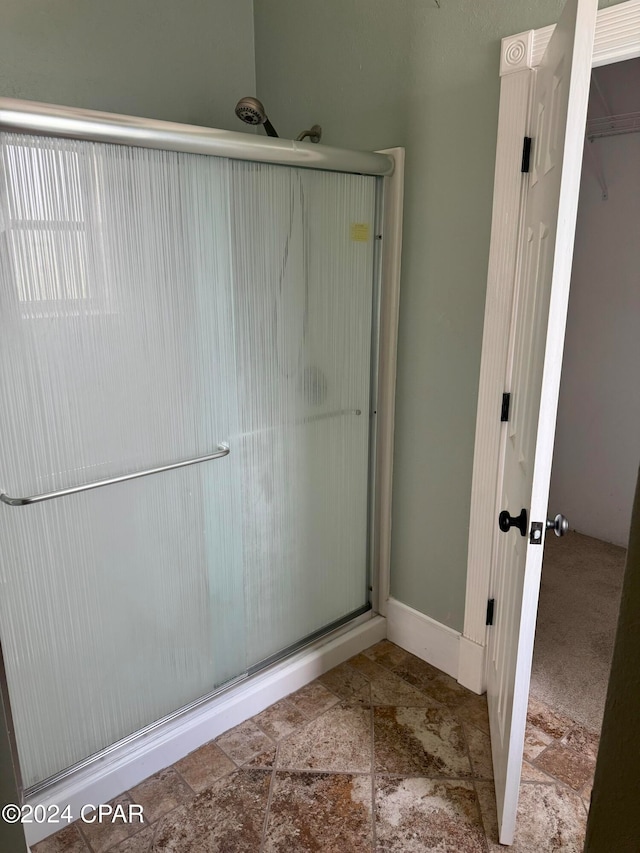 bathroom featuring a shower with door