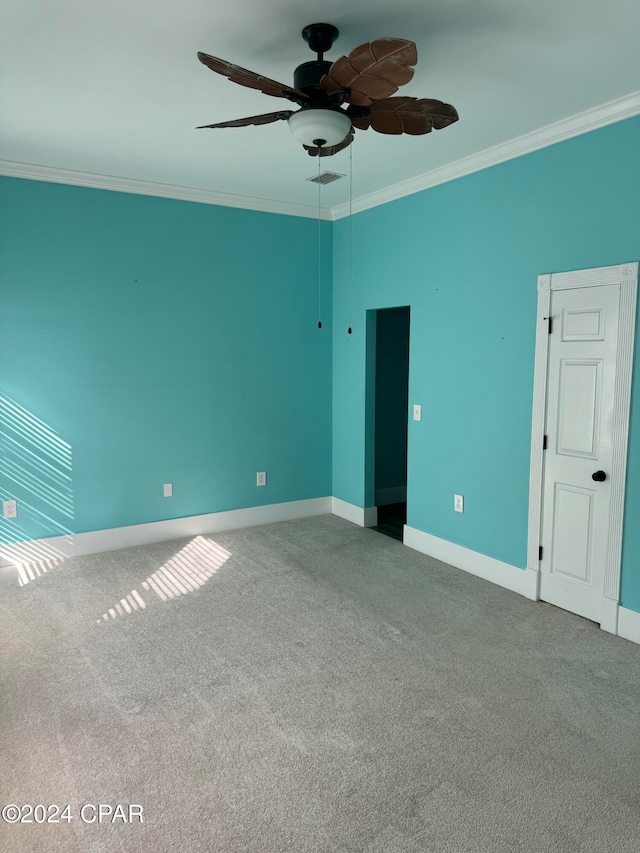 unfurnished room with ceiling fan, carpet floors, and ornamental molding