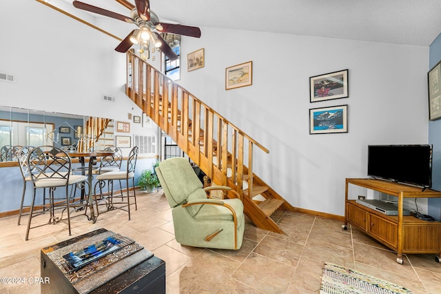 tiled living room featuring ceiling fan and high vaulted ceiling