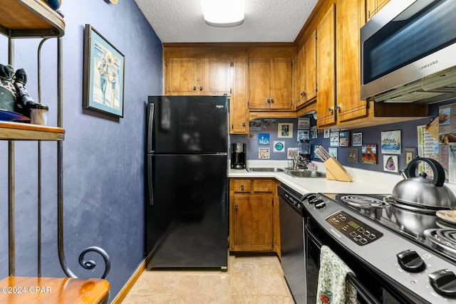 kitchen featuring light tile patterned floors, a textured ceiling, and black appliances