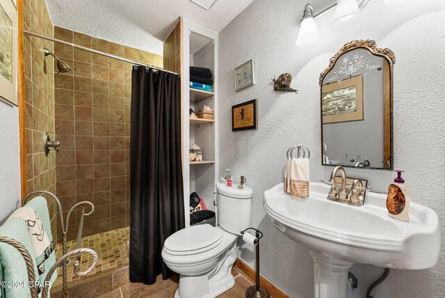 bathroom with toilet, a textured ceiling, and walk in shower