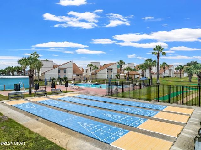 view of home's community with a pool and a yard