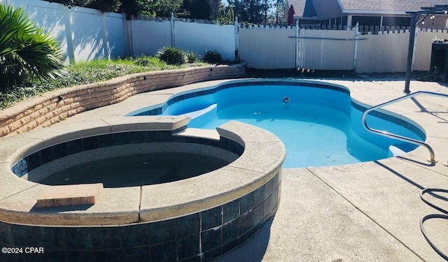 view of swimming pool with an in ground hot tub