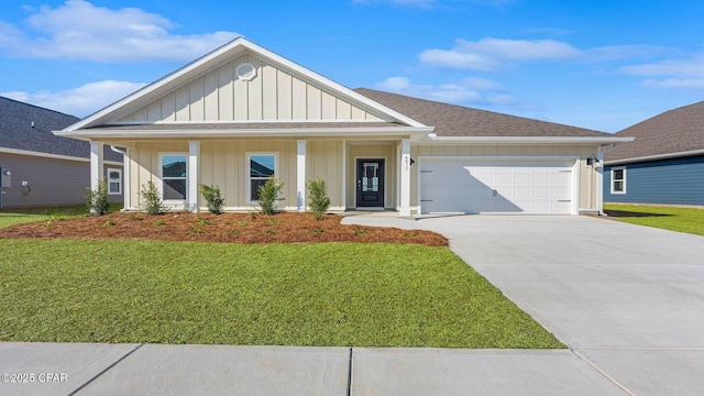 view of front of property featuring a garage, a front lawn, and covered porch