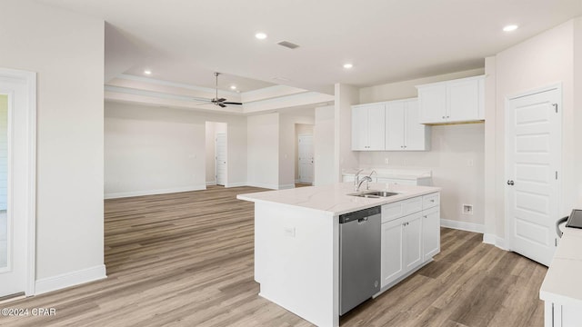 kitchen featuring sink, a kitchen island with sink, white cabinets, stainless steel dishwasher, and a raised ceiling