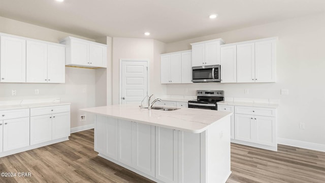 kitchen with white cabinetry, appliances with stainless steel finishes, a kitchen island with sink, and sink