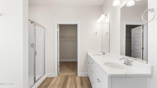 bathroom featuring walk in shower, vanity, and hardwood / wood-style flooring