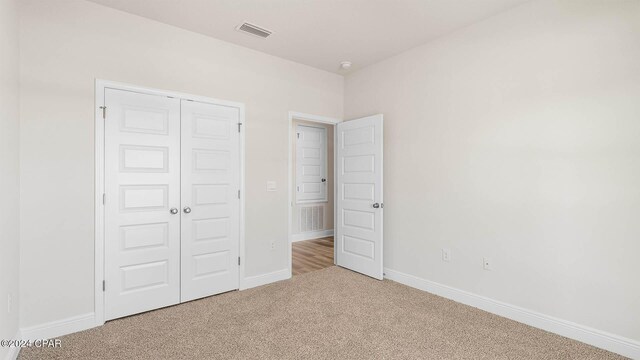 unfurnished bedroom featuring carpet and a closet