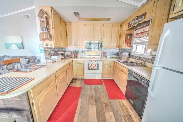 kitchen with kitchen peninsula, light wood-type flooring, tasteful backsplash, white appliances, and sink