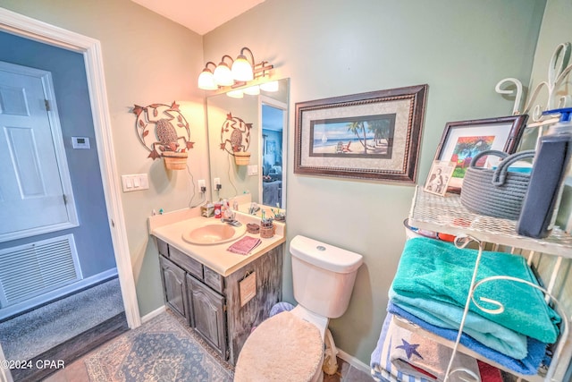 bathroom with hardwood / wood-style floors, vanity, and toilet