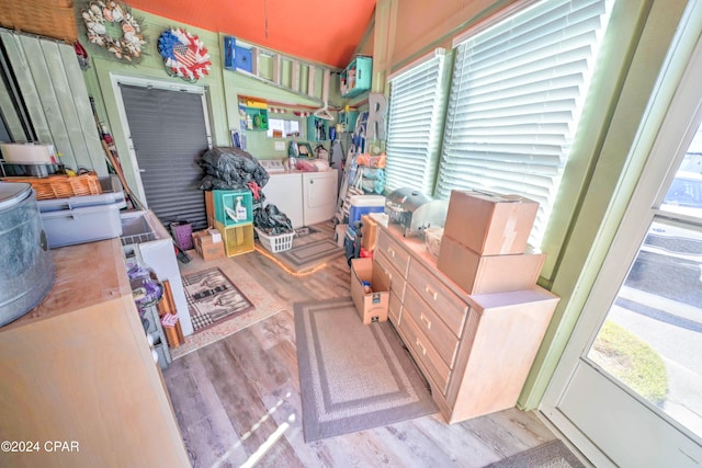 interior space with washing machine and clothes dryer, a wealth of natural light, and light hardwood / wood-style floors