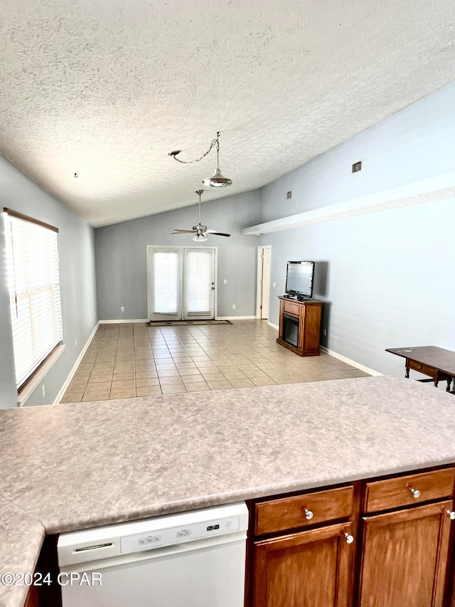 kitchen with lofted ceiling, white dishwasher, ceiling fan, a textured ceiling, and light tile patterned flooring