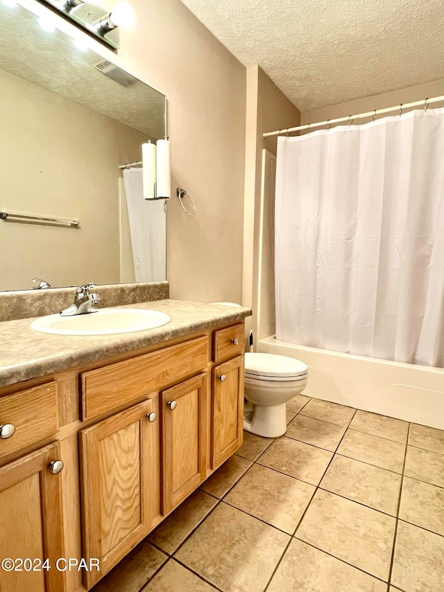 full bathroom with tile patterned flooring, vanity, a textured ceiling, and toilet