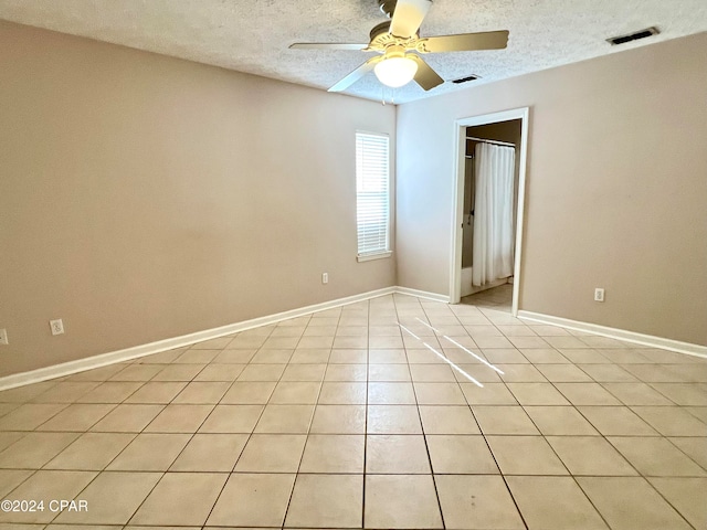 tiled spare room with ceiling fan and a textured ceiling