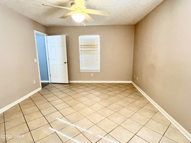 tiled spare room featuring ceiling fan and a textured ceiling