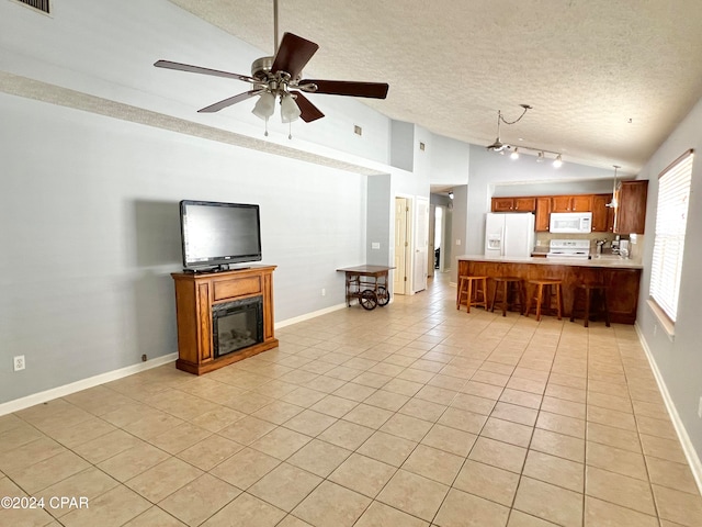 tiled living room with ceiling fan, a textured ceiling, and high vaulted ceiling