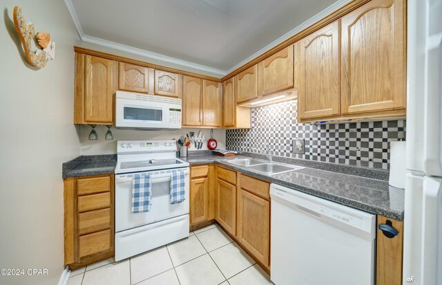 kitchen featuring crown molding, dark countertops, white appliances, and a sink