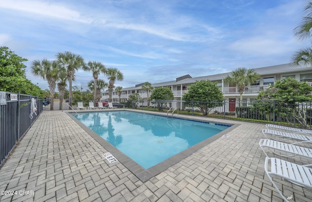 pool with fence and a patio