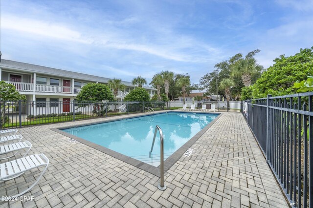 community pool with fence and a patio