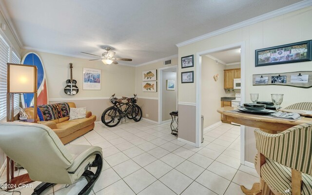 living room featuring ornamental molding, visible vents, ceiling fan, and light tile patterned floors