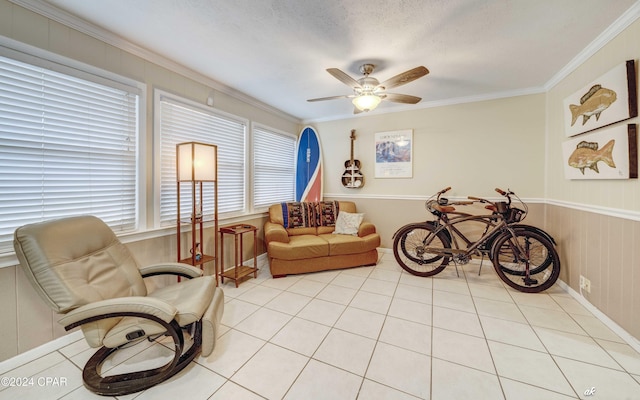 sitting room with light tile patterned floors, a ceiling fan, and crown molding