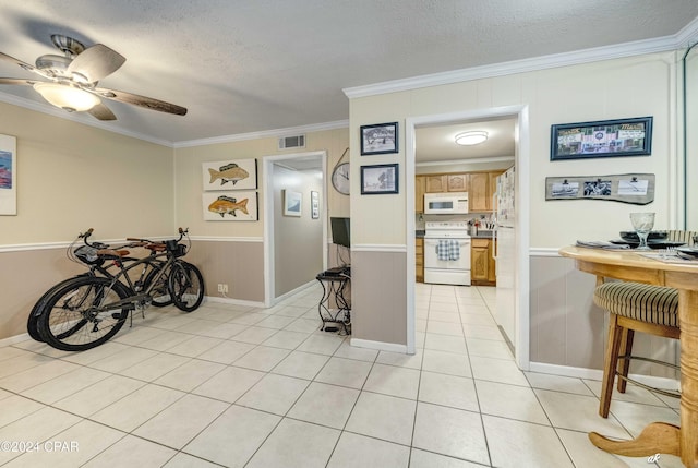 interior space with visible vents, ornamental molding, light tile patterned flooring, ceiling fan, and a textured ceiling