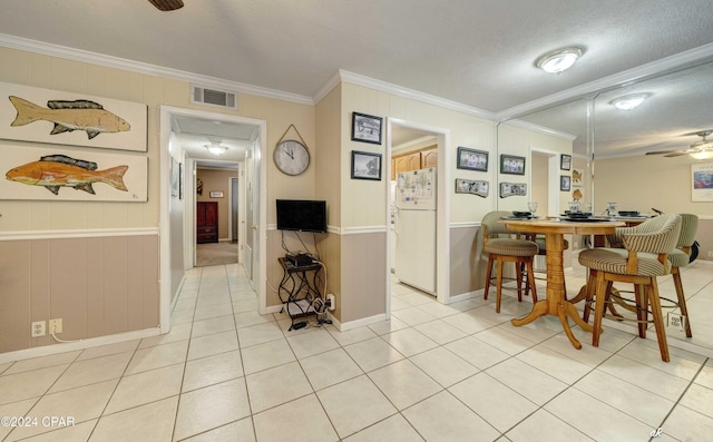 dining area featuring light tile patterned floors, ceiling fan, visible vents, and crown molding