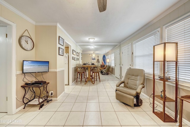 tiled dining room featuring ornamental molding, a ceiling fan, and baseboards