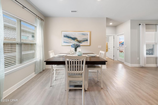 dining space with light wood-type flooring and a wealth of natural light