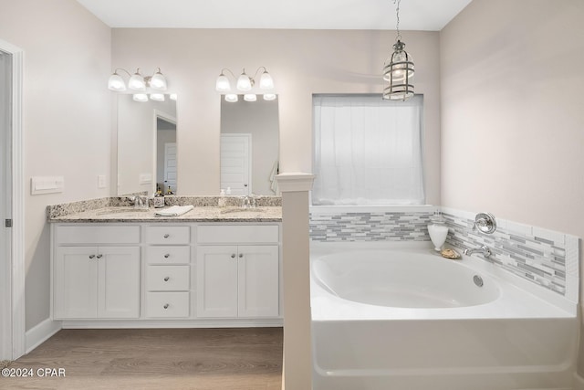 bathroom with hardwood / wood-style floors, vanity, and a tub