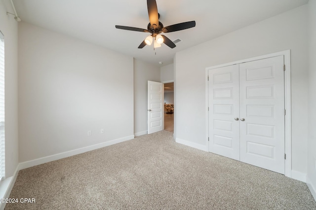 unfurnished bedroom featuring ceiling fan, a closet, and carpet