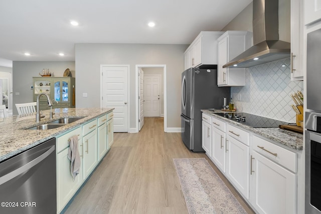 kitchen featuring light stone countertops, sink, wall chimney exhaust hood, and appliances with stainless steel finishes