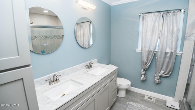 bathroom with vanity, crown molding, a shower, hardwood / wood-style floors, and toilet