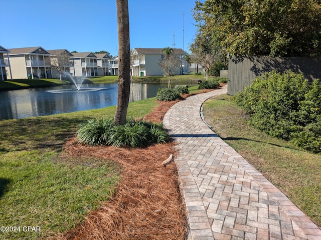 view of property's community featuring a yard and a water view