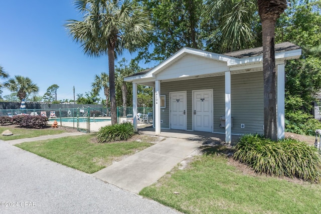 exterior space with a fenced in pool and a lawn