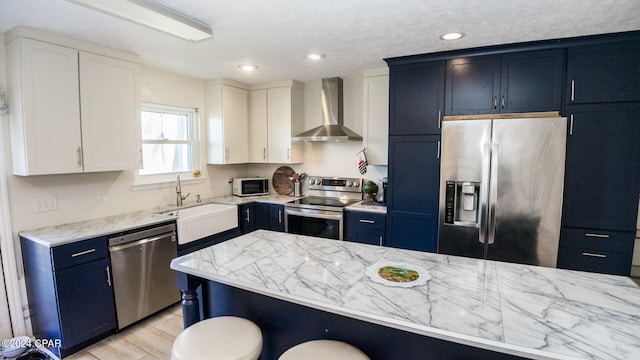 kitchen featuring white cabinets, sink, wall chimney exhaust hood, and appliances with stainless steel finishes