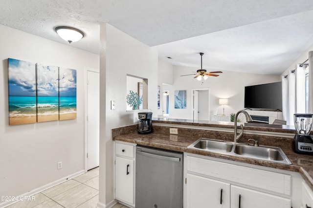 kitchen featuring ceiling fan, sink, stainless steel dishwasher, vaulted ceiling, and white cabinets