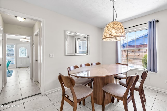 tiled dining room with a wealth of natural light and a textured ceiling