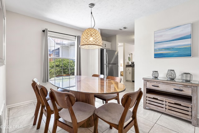 tiled dining room featuring a textured ceiling