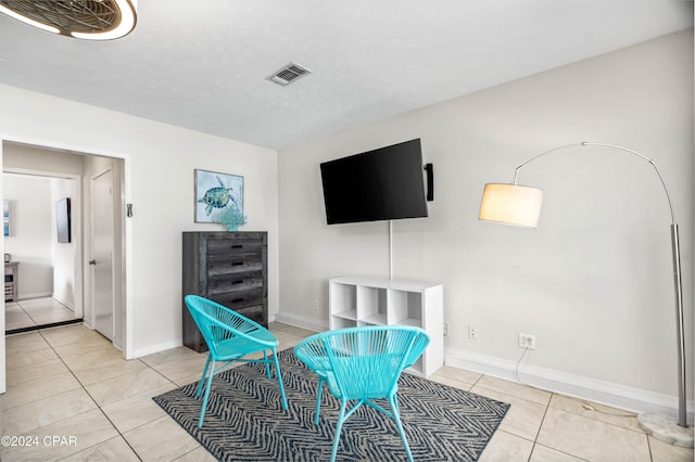 living area featuring light tile patterned floors and a textured ceiling