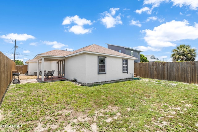 back of property with a lawn and a patio