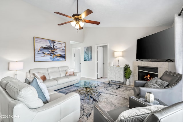 living room with ceiling fan, a fireplace, and high vaulted ceiling